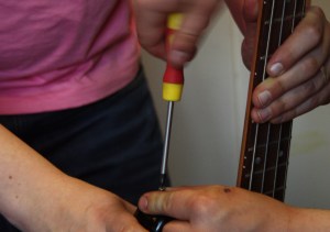 Plötsligt kommer en scenarbetare med en trasig bas - axelbandets fäste lagas på under två minuter. Foto: David Fryxelius.